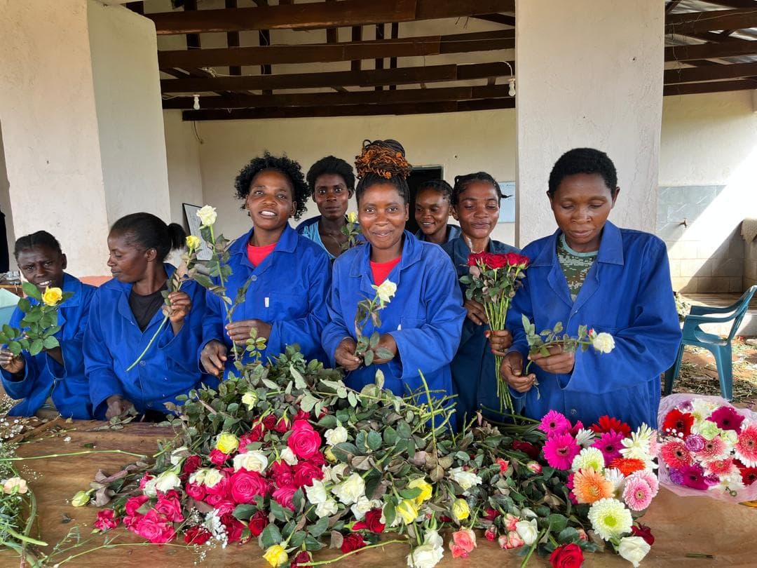 Women of the Hillview team with a table of freshly cut roses and gerberas